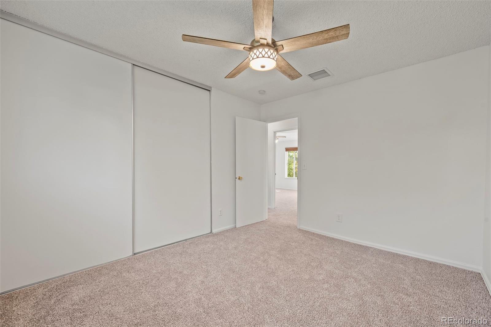 4420 South Vivian Way Morrison, CO 80465 - Photo 24 of 50 a view of an empty room with a chandelier fan
