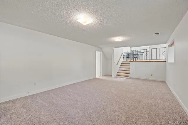 a view of an empty room with stairs and ventilation