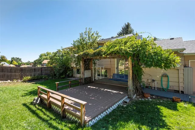 a view of a backyard with couches plants and large trees
