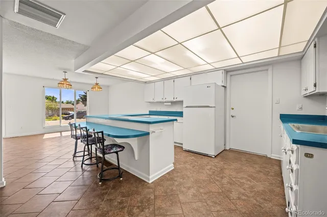 a kitchen with stainless steel appliances granite countertop a table chairs and a refrigerator