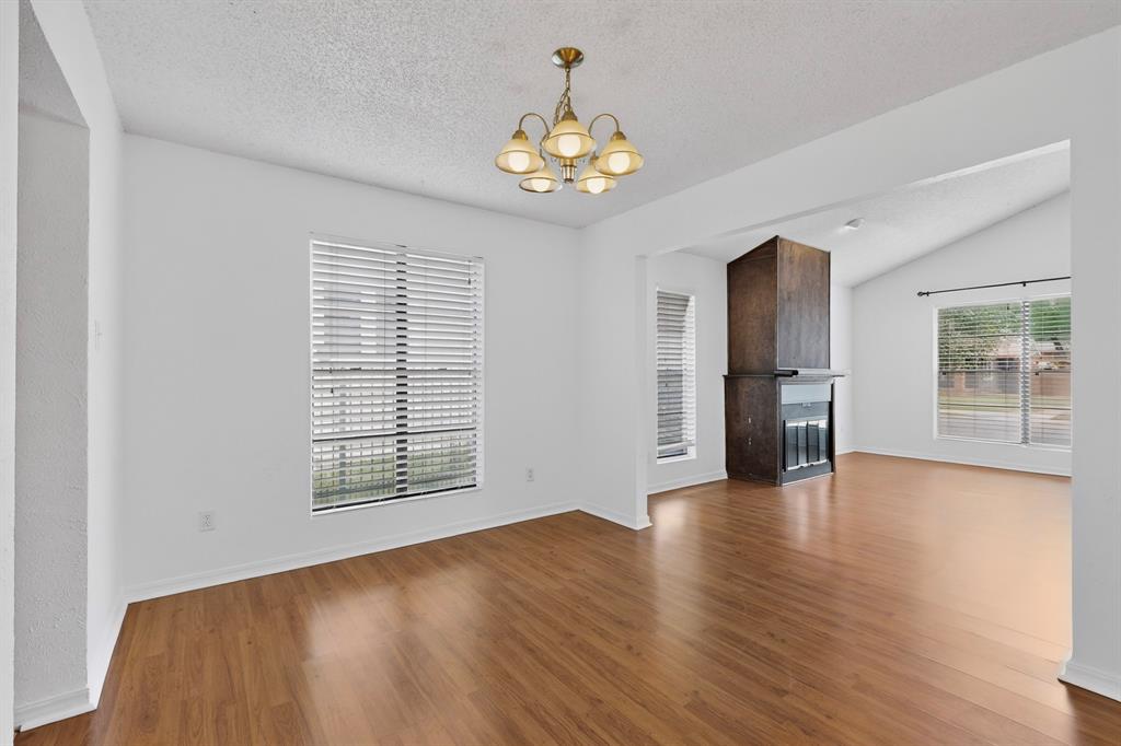 635 Haines Avenue Dallas, TX 75208 - Photo 11 of 36 an empty room with wooden floor chandelier and windows