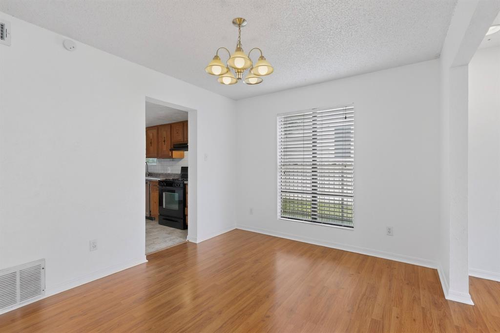 635 Haines Avenue Dallas, TX 75208 - Photo 13 of 36 a view of an empty room with a window and wooden floor