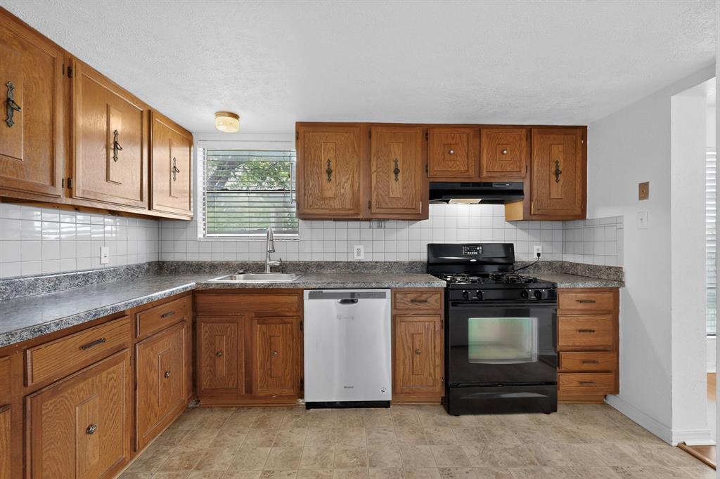 635 Haines Avenue Dallas, TX 75208 - Photo 16 of 36 a kitchen with stainless steel appliances granite countertop a stove a sink and a microwave