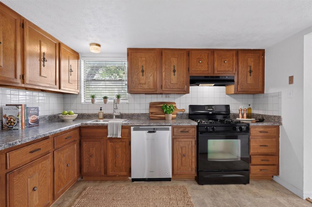 635 Haines Avenue Dallas, TX 75208 - Photo 17 of 36 a kitchen with stainless steel appliances granite countertop a stove a sink and a white cabinets