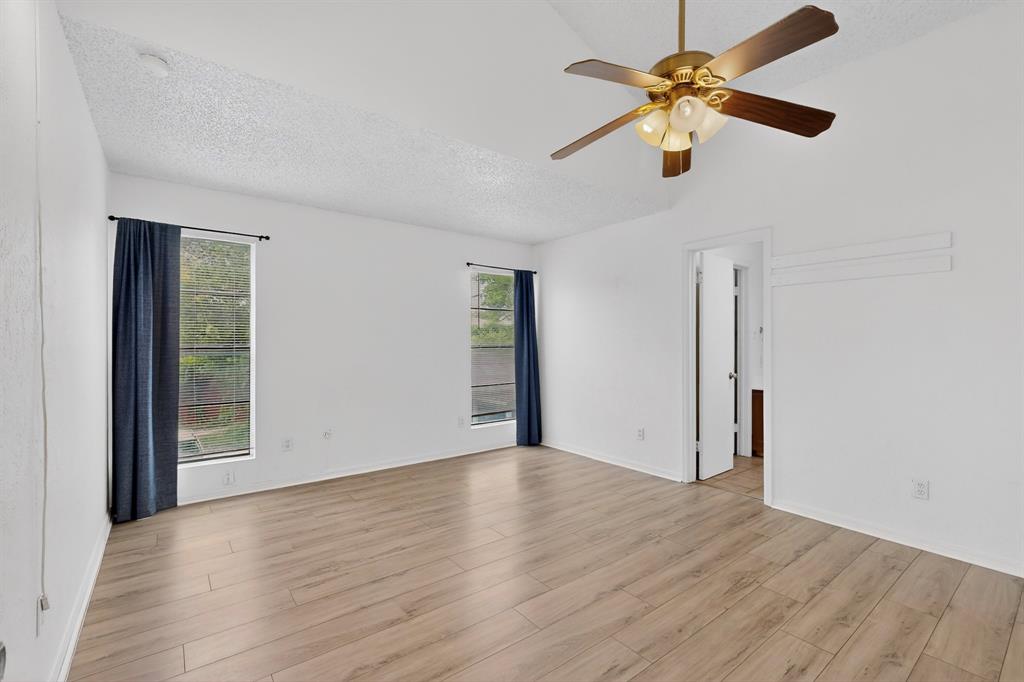 635 Haines Avenue Dallas, TX 75208 - Photo 30 of 36 an empty room with wooden floor chandelier fan and windows