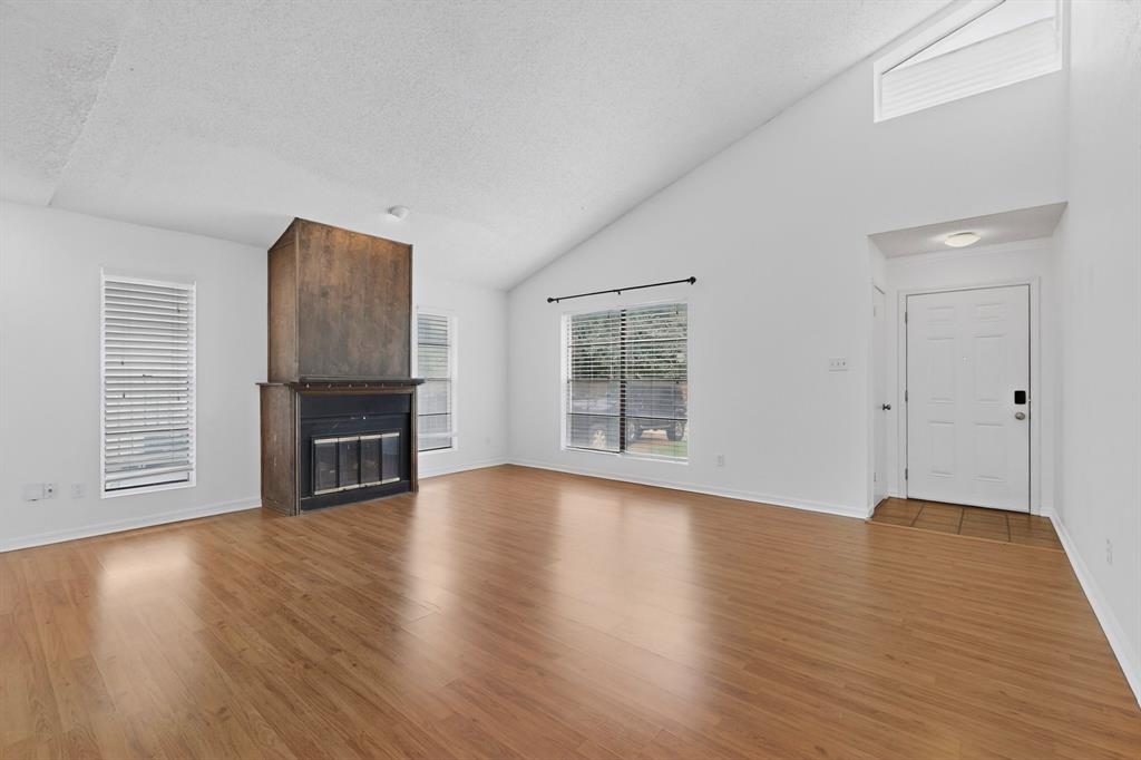 635 Haines Avenue Dallas, TX 75208 - Photo 6 of 36 a view of an empty room with wooden floor and a window
