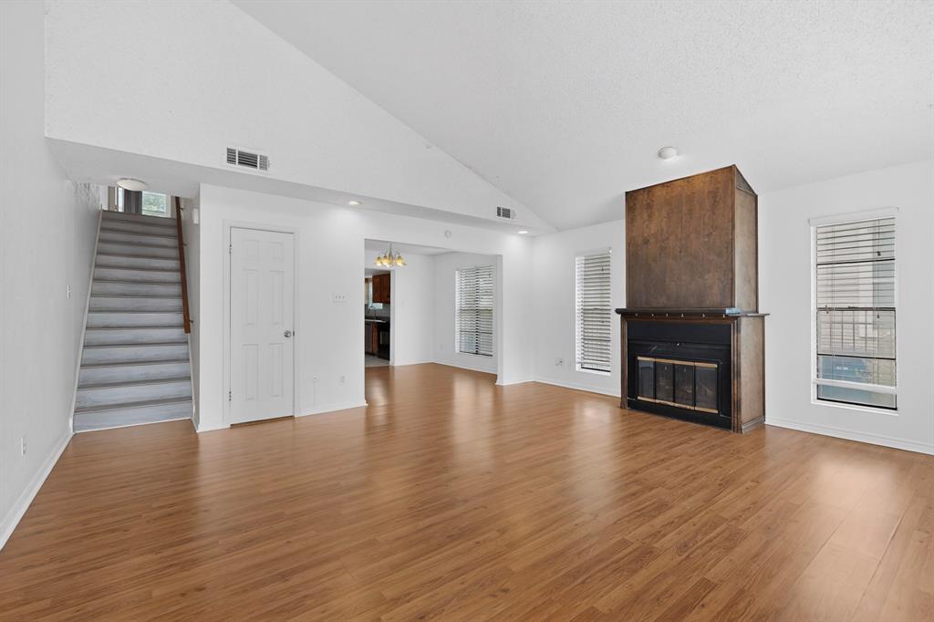 635 Haines Avenue Dallas, TX 75208 - Photo 7 of 36 a view of an empty room with a kitchen and wooden floor