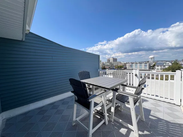 a view of a patio with table and chairs with wooden floor and fence