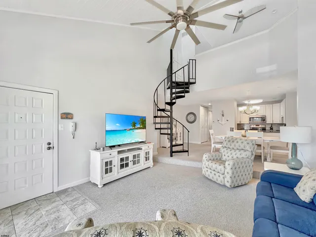 a living room with furniture a flat screen tv and a large window