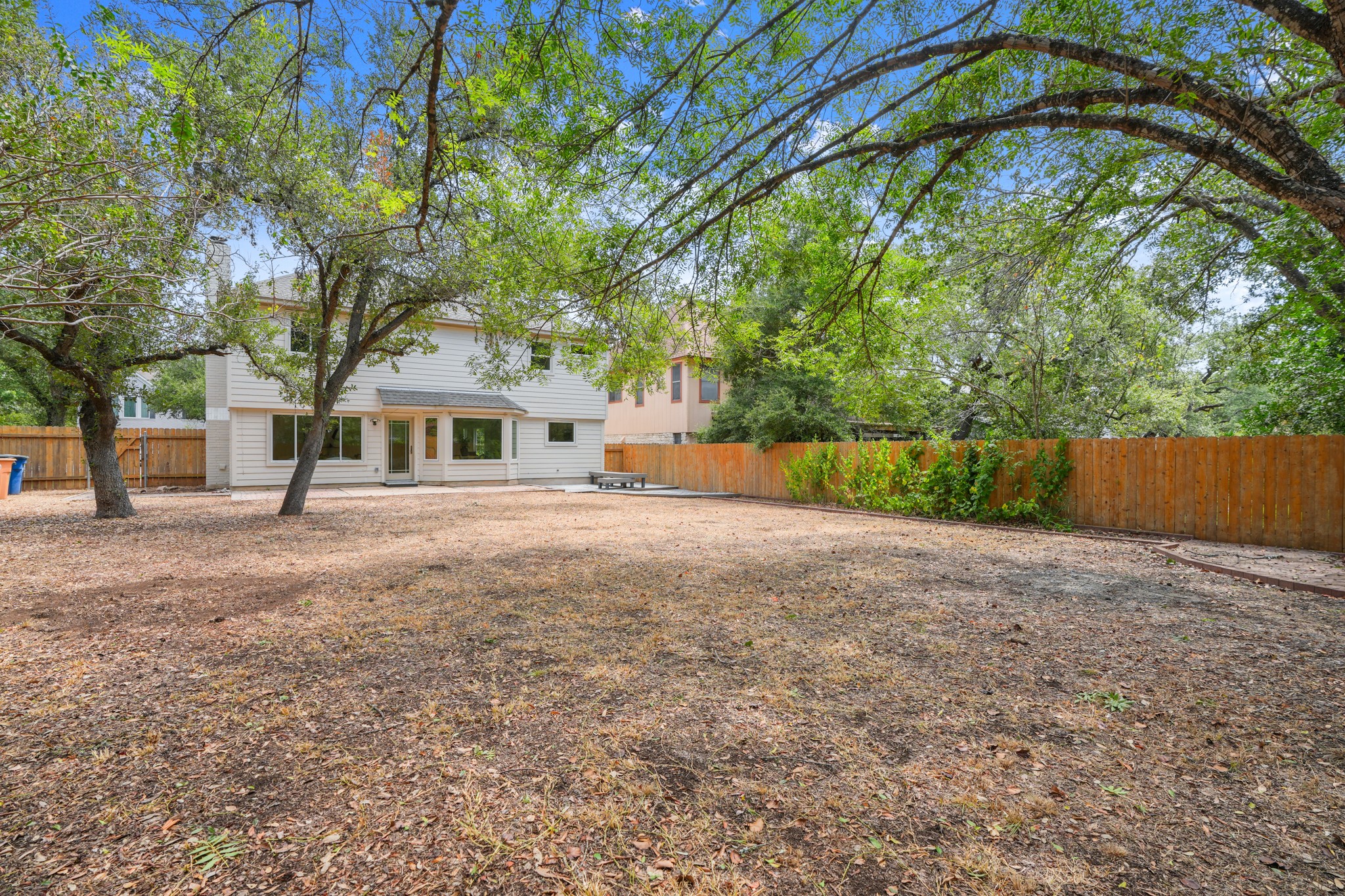 7826 Wheel Rim Circle Austin, TX 78749 - Photo 28 of 38 Mature trees shade a spacious backyard fully enclosed by wooden fencing.