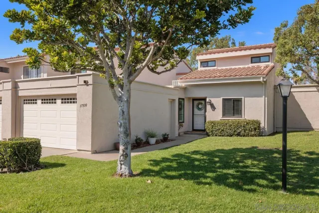 a view of a house with backyard and a tree