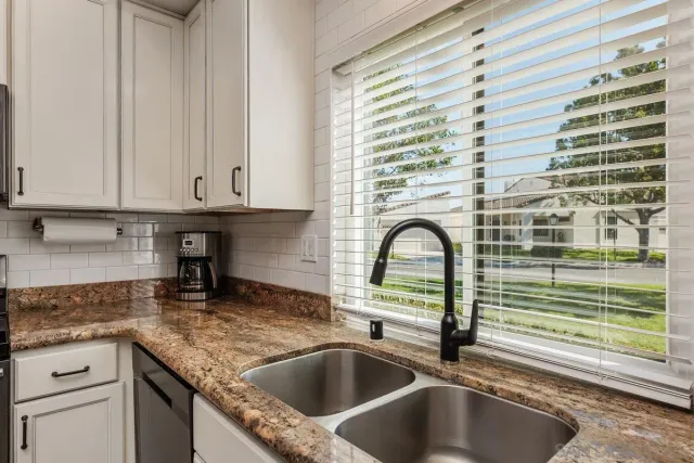 a kitchen with granite countertop a sink and a stove