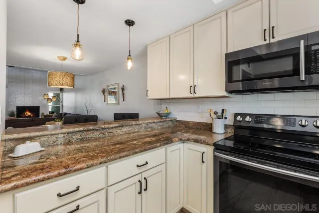 a kitchen with stainless steel appliances granite countertop a sink and a stove