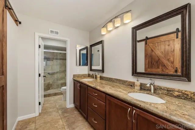 a bathroom with a granite countertop sink mirror and double