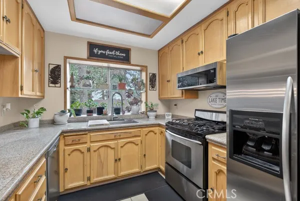 a kitchen with stainless steel appliances granite countertop a stove a sink and a microwave