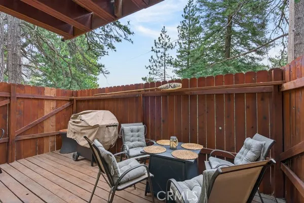 a view of a patio with table and chairs with wooden floor and fence