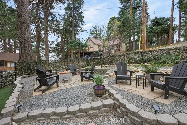 a view of a patio with table and chairs potted plants and large tree