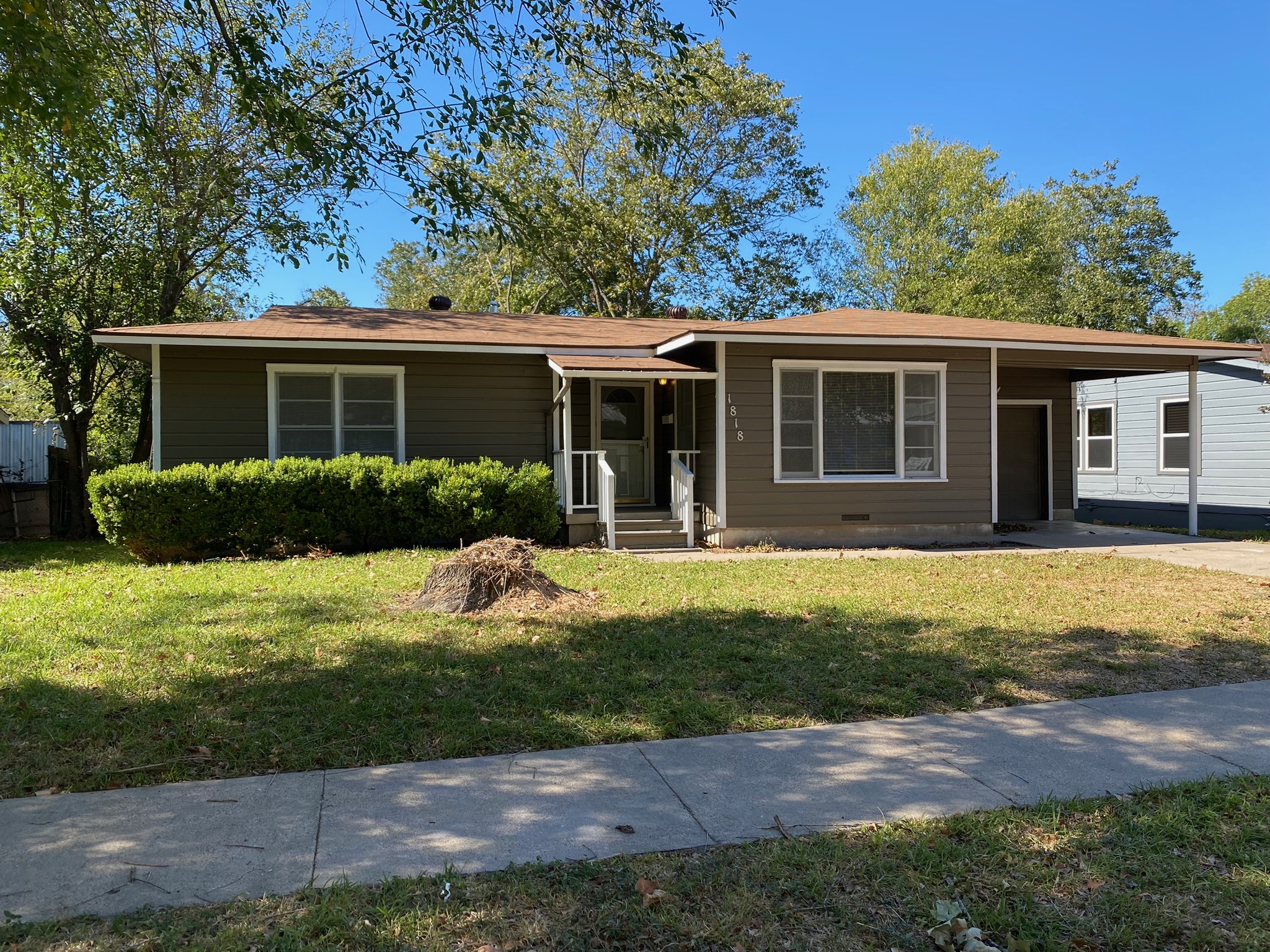 Ranch-style home with a front lawn and a carport
