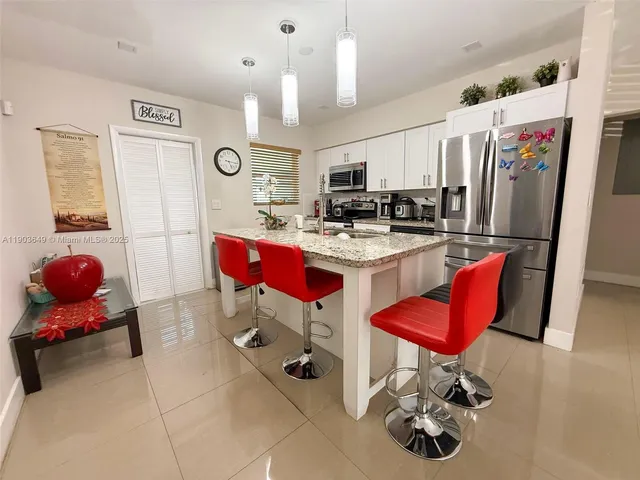 a room with kitchen island dining table and chairs