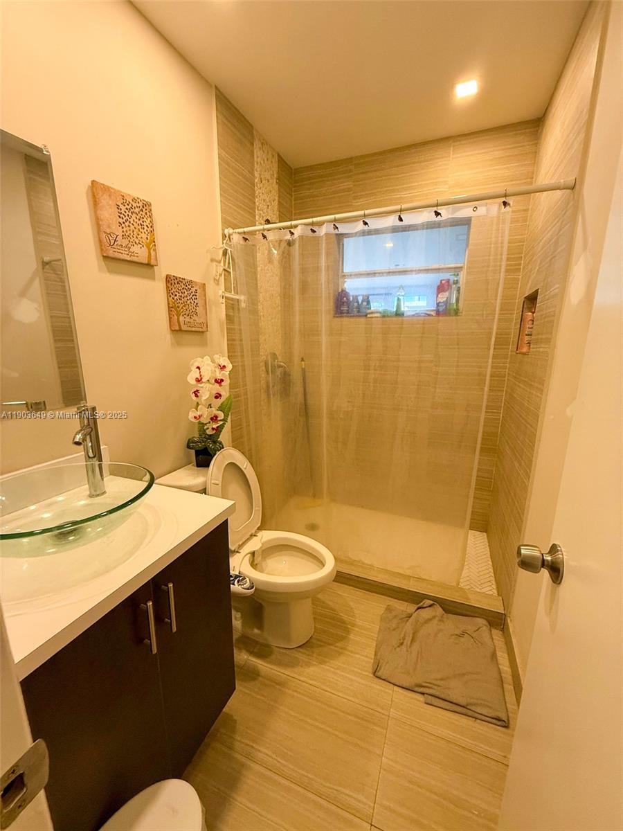 1545 Northwest 85th Street Miami, FL 33147 - Photo 6 of 16 a bathroom with a granite countertop sink toilet and shower
