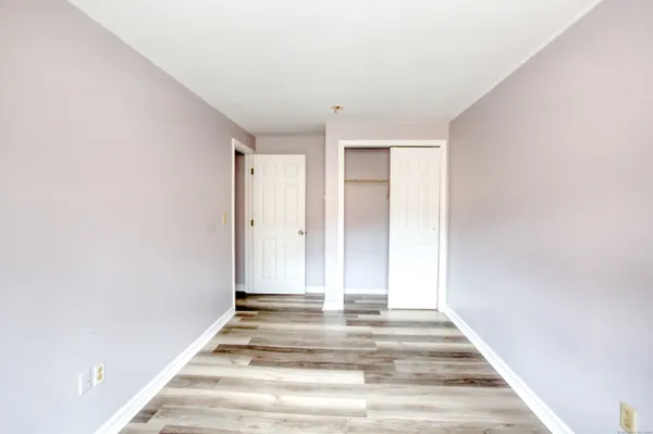 an empty room with wooden floor and a window