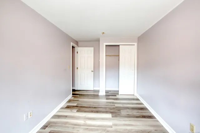 an empty room with wooden floor and a window