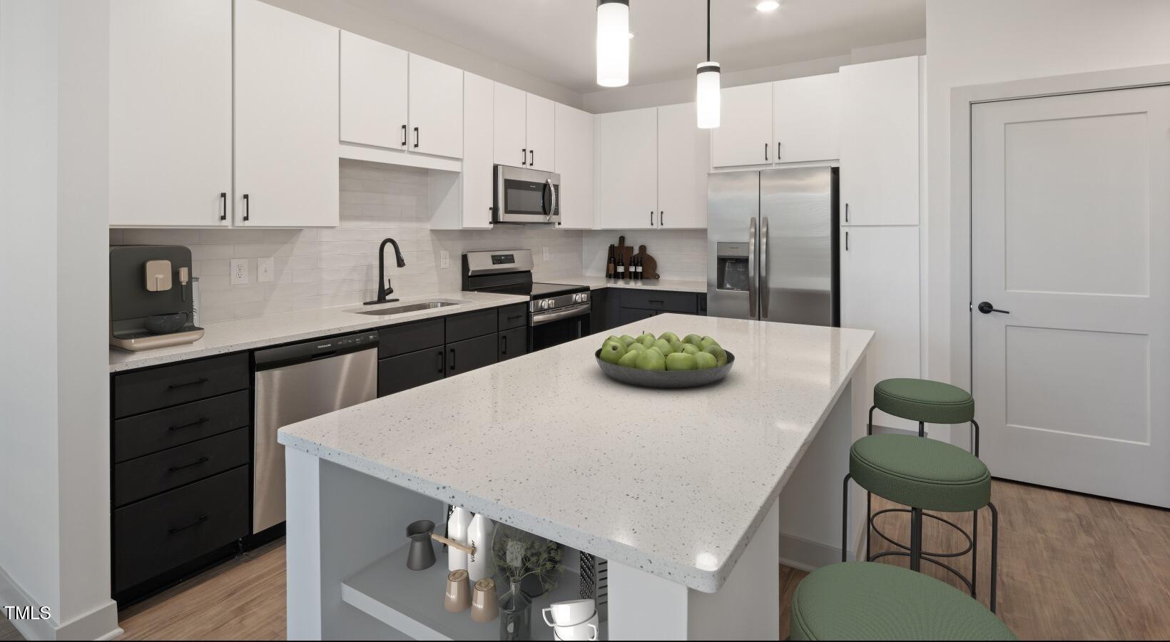 1821 Chatham Flats Drive, Unit A1 Apex, NC 27502 - Photo 4 of 12 a kitchen with stainless steel appliances a stove a sink a refrigerator and white cabinets with wooden floor