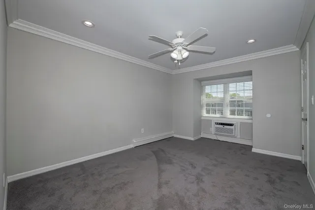 an empty room with a window and a fan