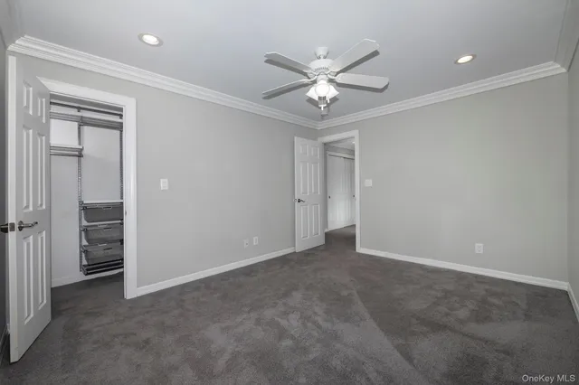 an empty room with closet and a ceiling fan