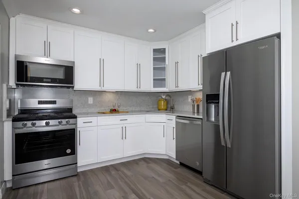 a kitchen with stainless steel appliances a refrigerator stove and microwave