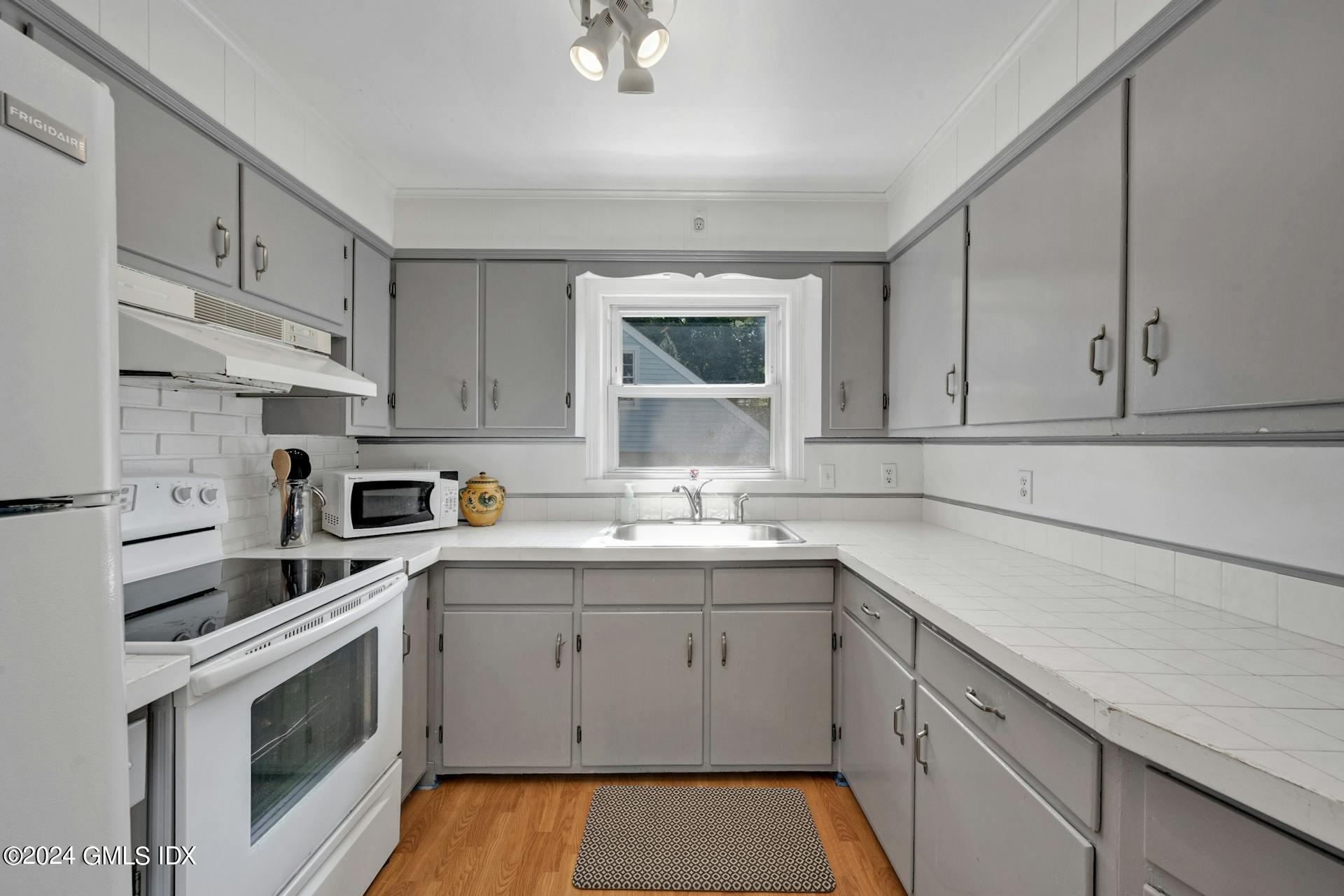 334 Palmer Hill Road Riverside, CT 06878 - Photo 12 of 19 a kitchen with a sink stove and cabinets