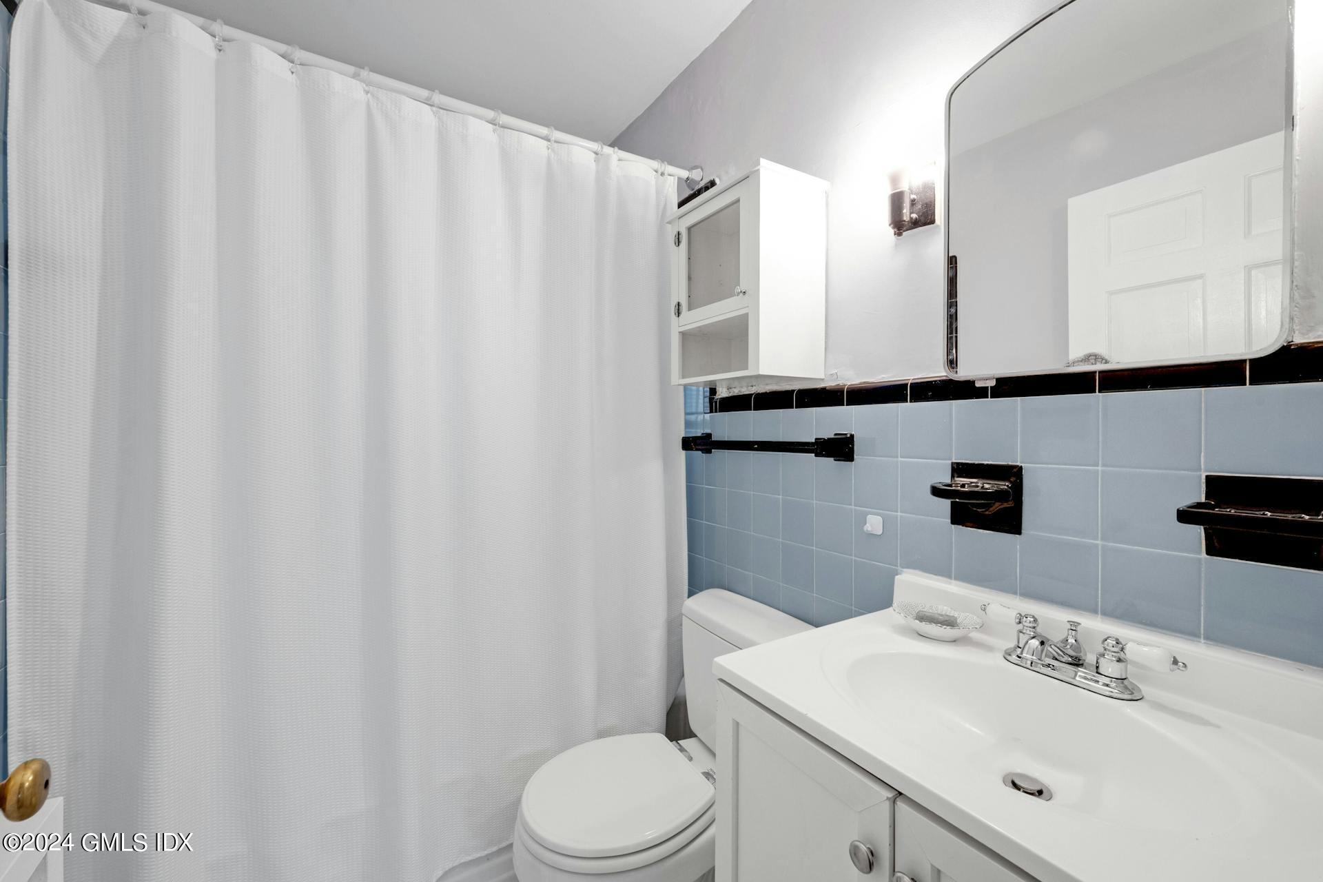 334 Palmer Hill Road Riverside, CT 06878 - Photo 7 of 19 a bathroom with a sink a toilet and shower curtain