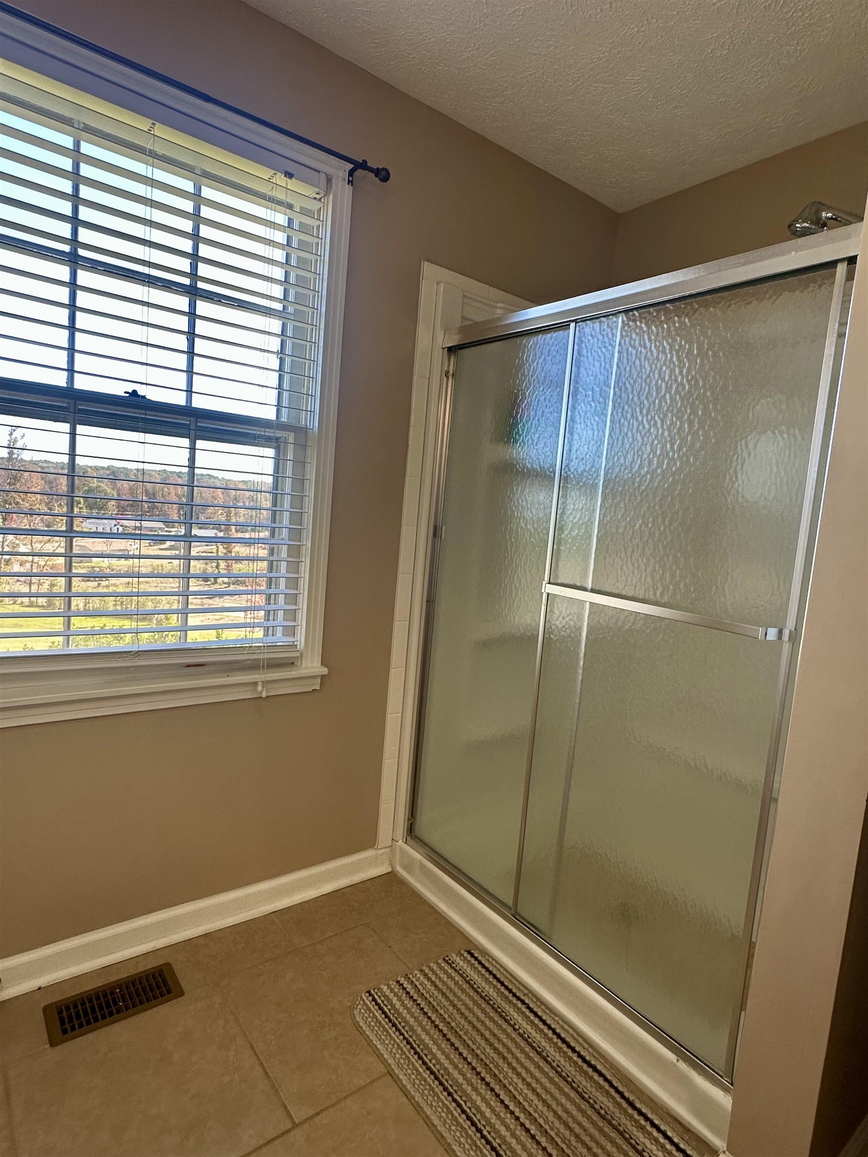 136 Perkins Street Selmer, TN 38375 - Photo 13 of 25 a bathroom with a glass shower door