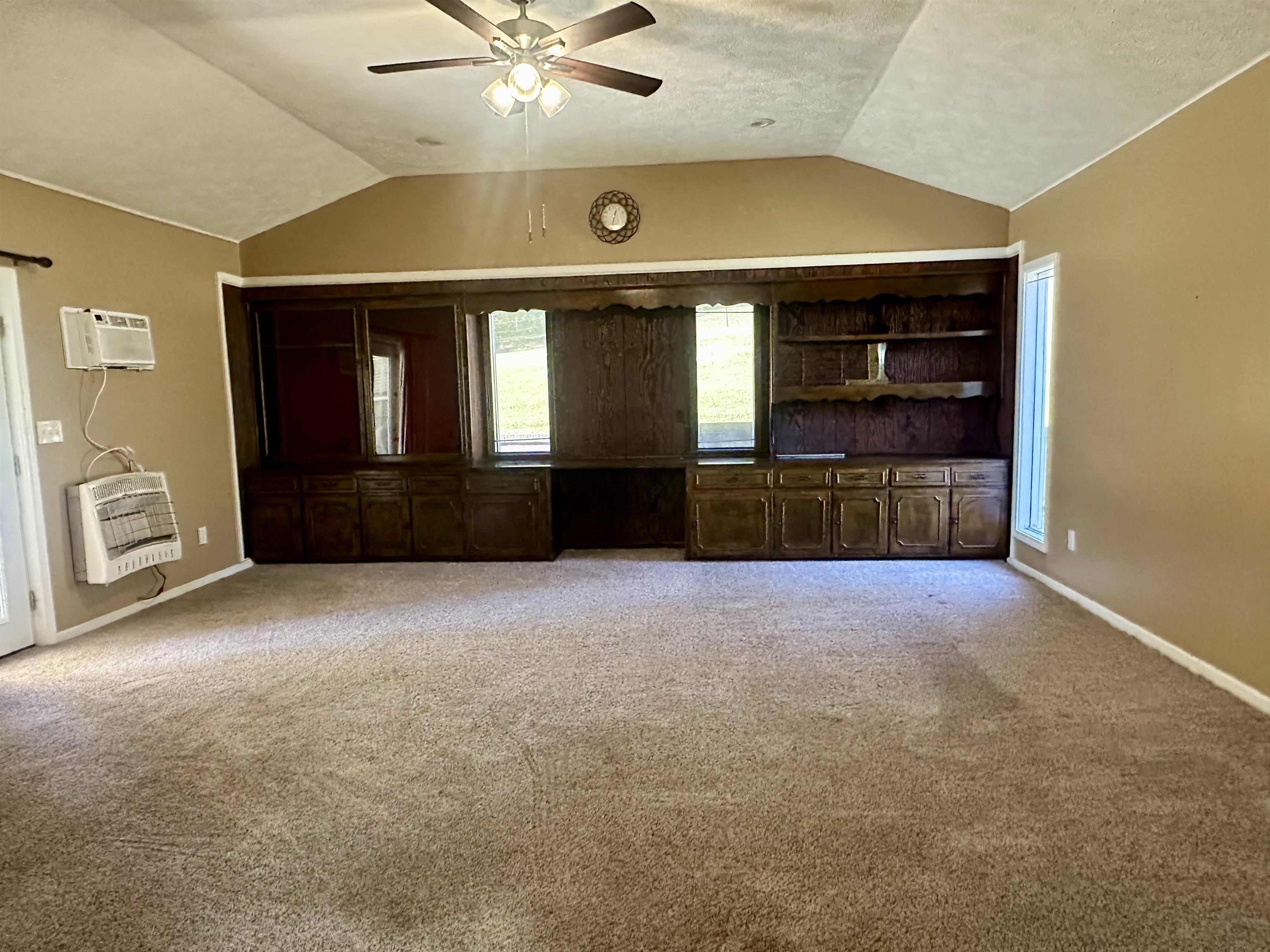 136 Perkins Street Selmer, TN 38375 - Photo 2 of 25 en empty room with windows and ceiling fan