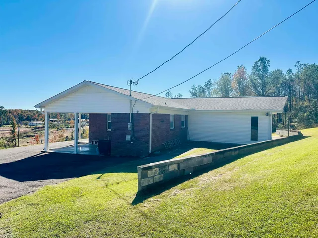 a front view of house with yard and trees in the background