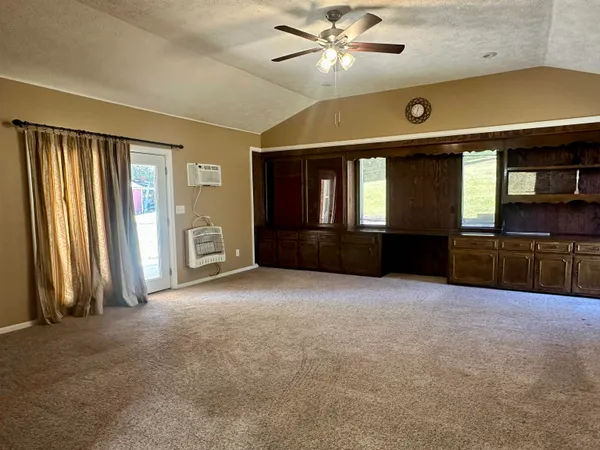 an empty room with windows and ceiling fan