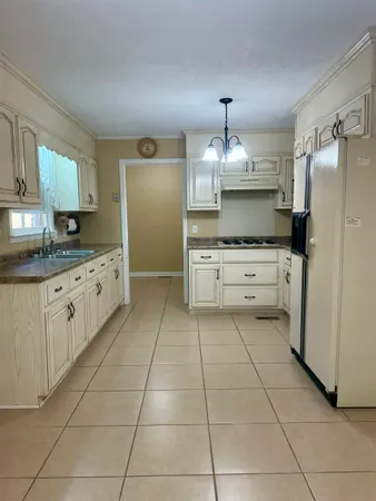 a kitchen with kitchen island granite countertop a stove a sink and a refrigerator