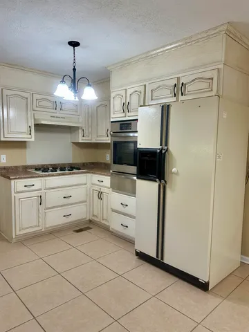 a kitchen with white cabinets and white appliances