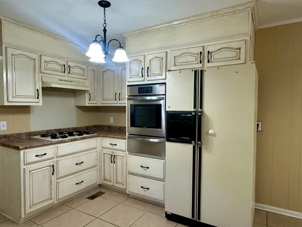 a kitchen with white cabinets and white appliances
