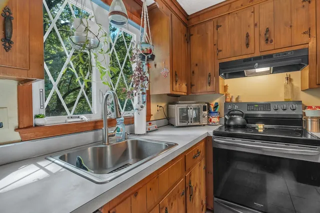 a kitchen with stainless steel appliances a sink a stove a microwave and cabinets