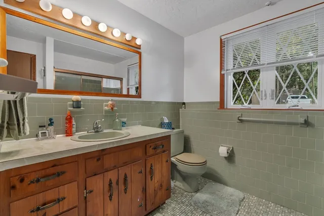 a bathroom with a toilet sink and mirror