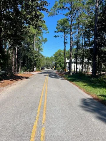 a view of street with houses and trees in the background