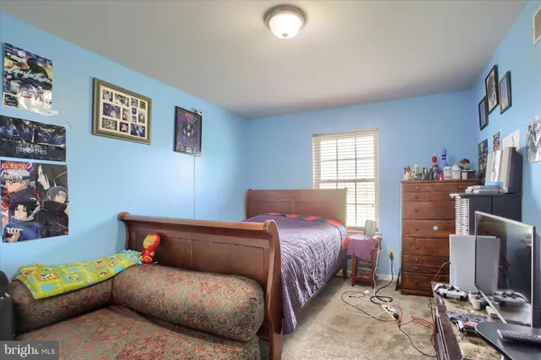 a bedroom with a bed couch and a window