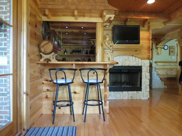 a living room with chairs wooden floor and a fireplace