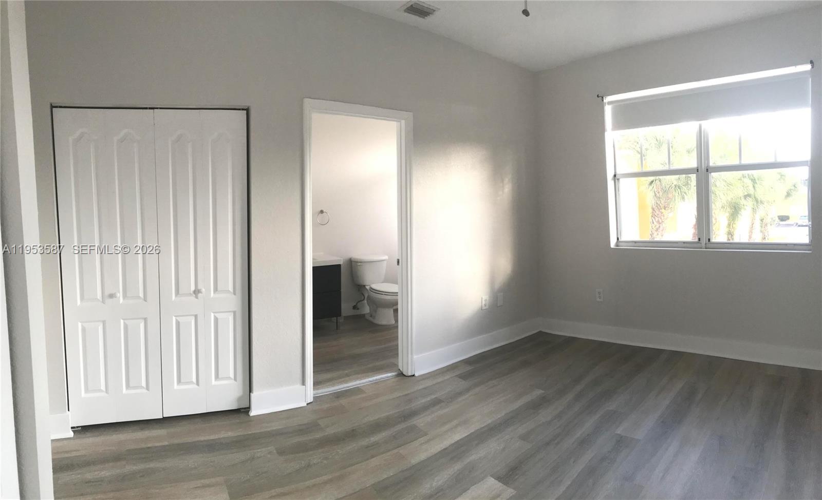2201 Monroe Street, Unit B2 Hollywood, FL 33020 - Photo 7 of 12 an empty room with wooden floor and windows