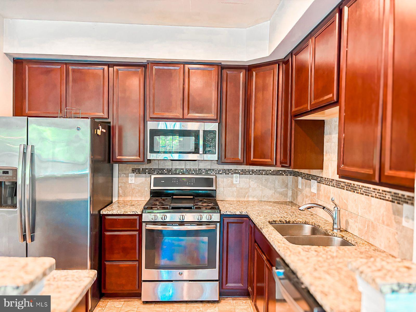63 Franklin Circle, Unit 63 Somerdale, NJ 08083 - Photo 7 of 18 a kitchen with a stove a sink and a refrigerator