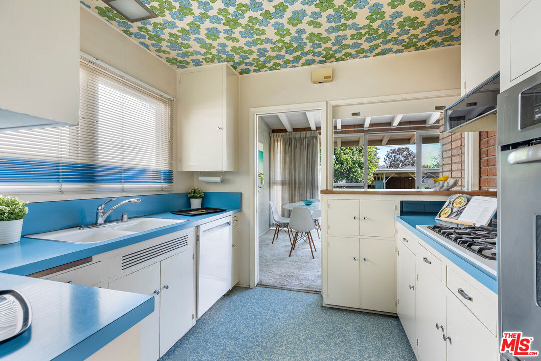 11368 Berwick Street Los Angeles, CA 90049 - Photo 11 of 31 a kitchen that has a lot of cabinets in it and wooden floor