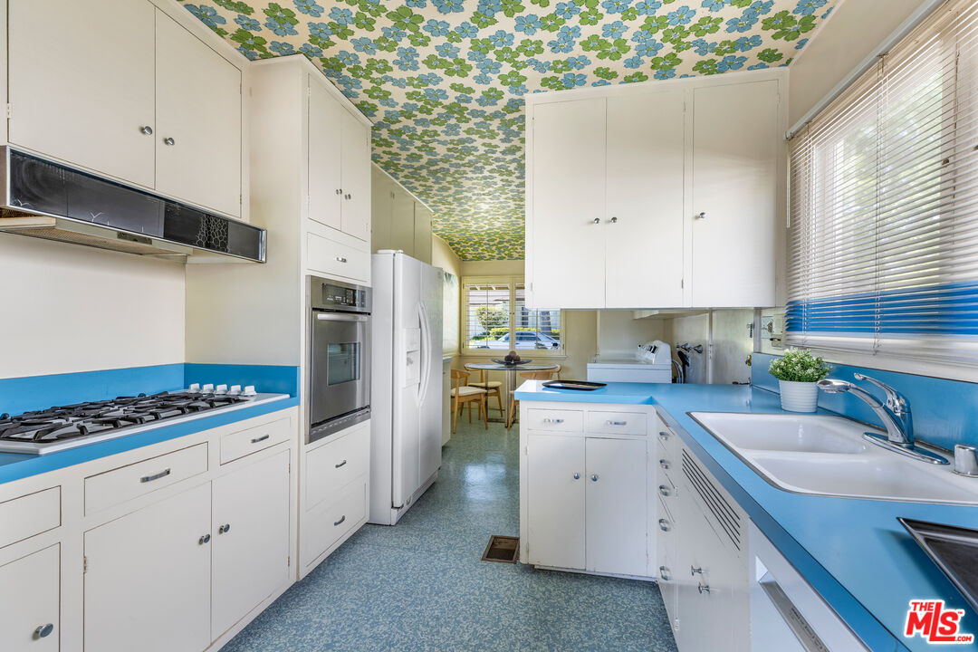 11368 Berwick Street Los Angeles, CA 90049 - Photo 12 of 31 a kitchen with white cabinets and appliances