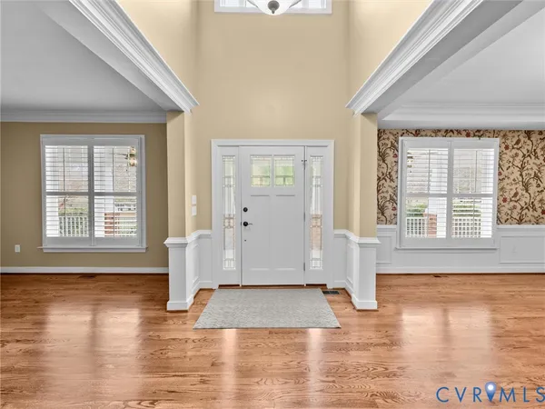 a view of an empty room with wooden floor fireplace and a window