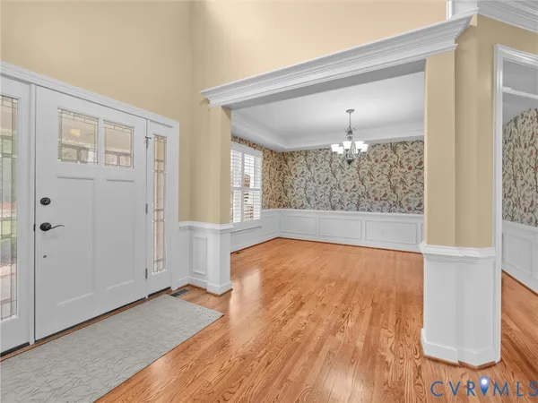a view of an empty room with wooden floor fireplace and a window
